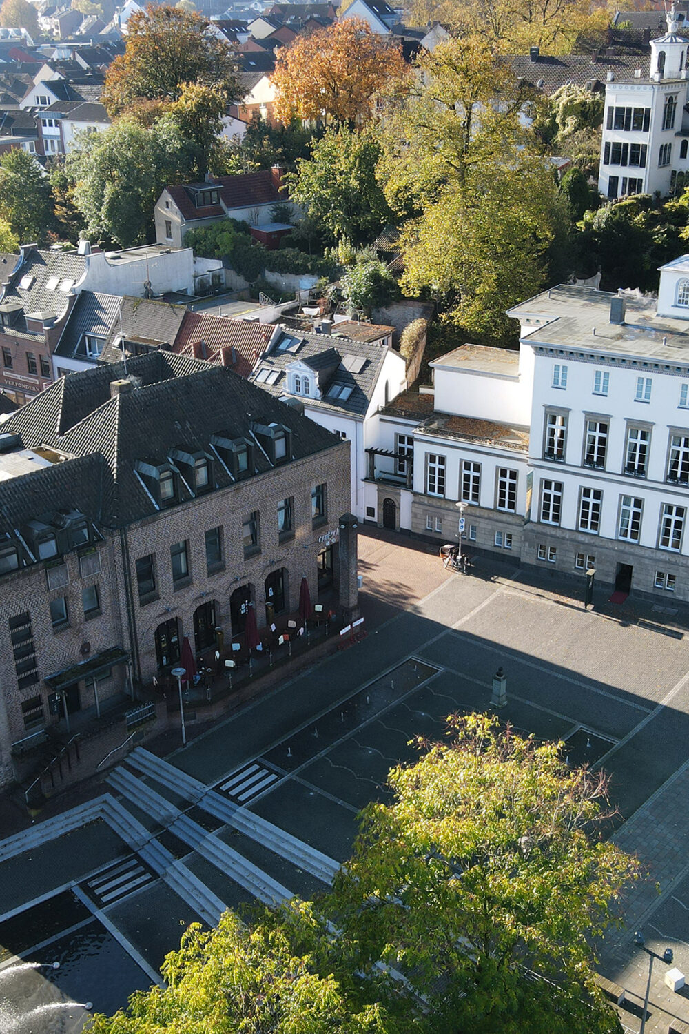 Sicht von oben auf Turm, Marktplatz und ein weißes Gebäude.