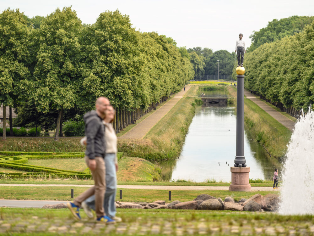 Zwei Spaziergänger wandern durch einen Park.