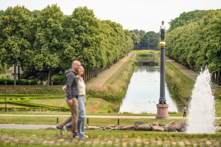 Zwei Spaziergänger wandern durch einen Park.