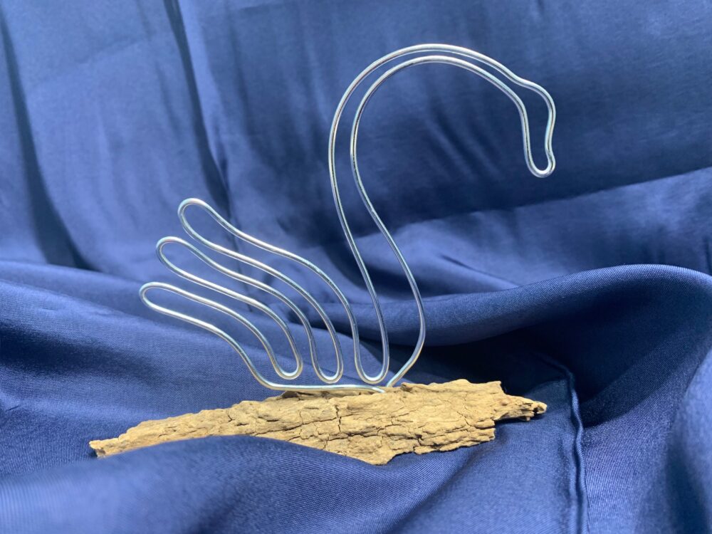 Handgefertigte Drahtschwäne auf Holzstücken