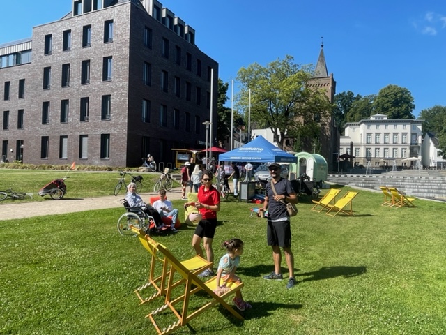 Menschen in Liegestühlen verweilen auf einer Wiese