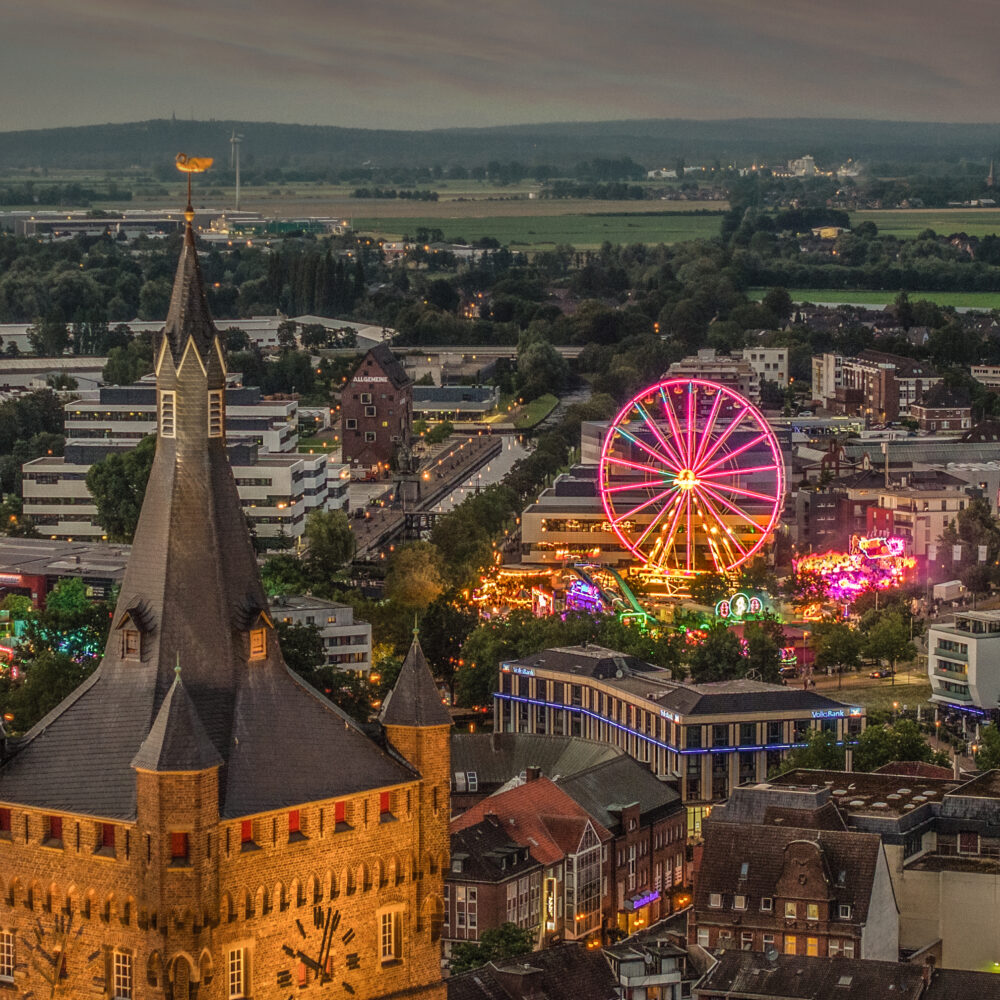 Beleuchtete Burgturm und beleuchtetes Riesenrad.