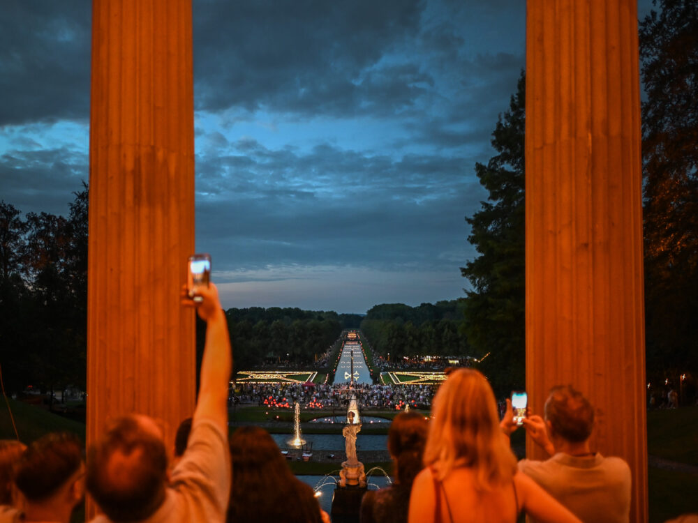 Menschen fotografieren beleuchtete Gartenanlagen beim Klever Lichterfest