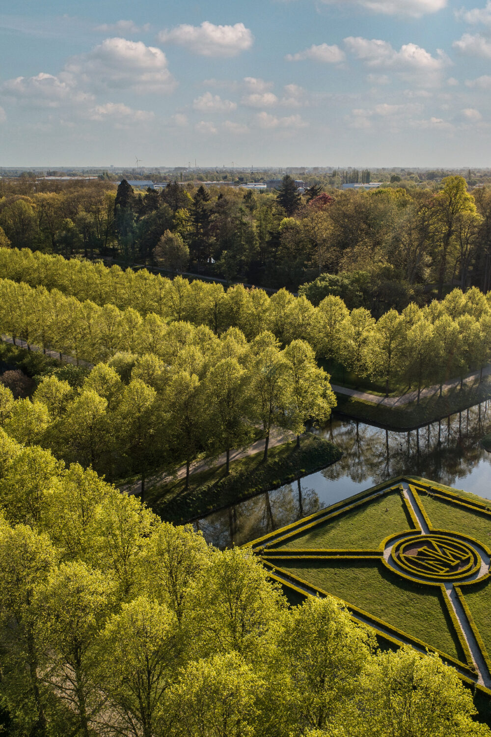 Vogelperspektive auf die Gartenanlagen mit den schnurgerade Baumalleen und dem Moritzkanal