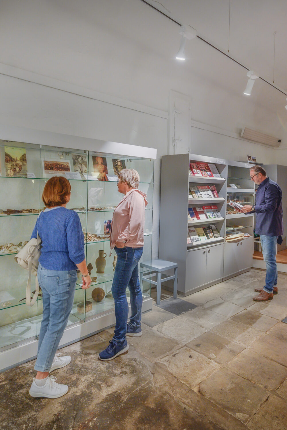 mehrere Personen halten sich im Eingangsbereich des Schwanenturms auf, links eine Schaufensterpuppe mit dem Gewand von Anna von Cleve