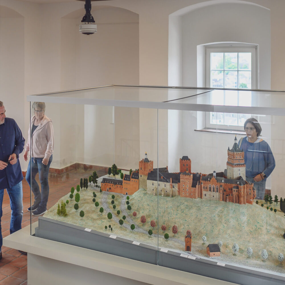 Personen betrachten das Modell der Schwanenburg