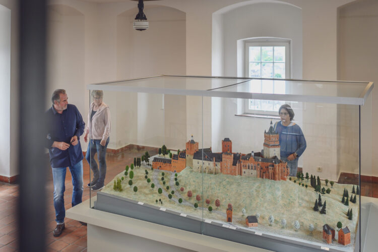 Personen betrachten das Modell der Schwanenburg