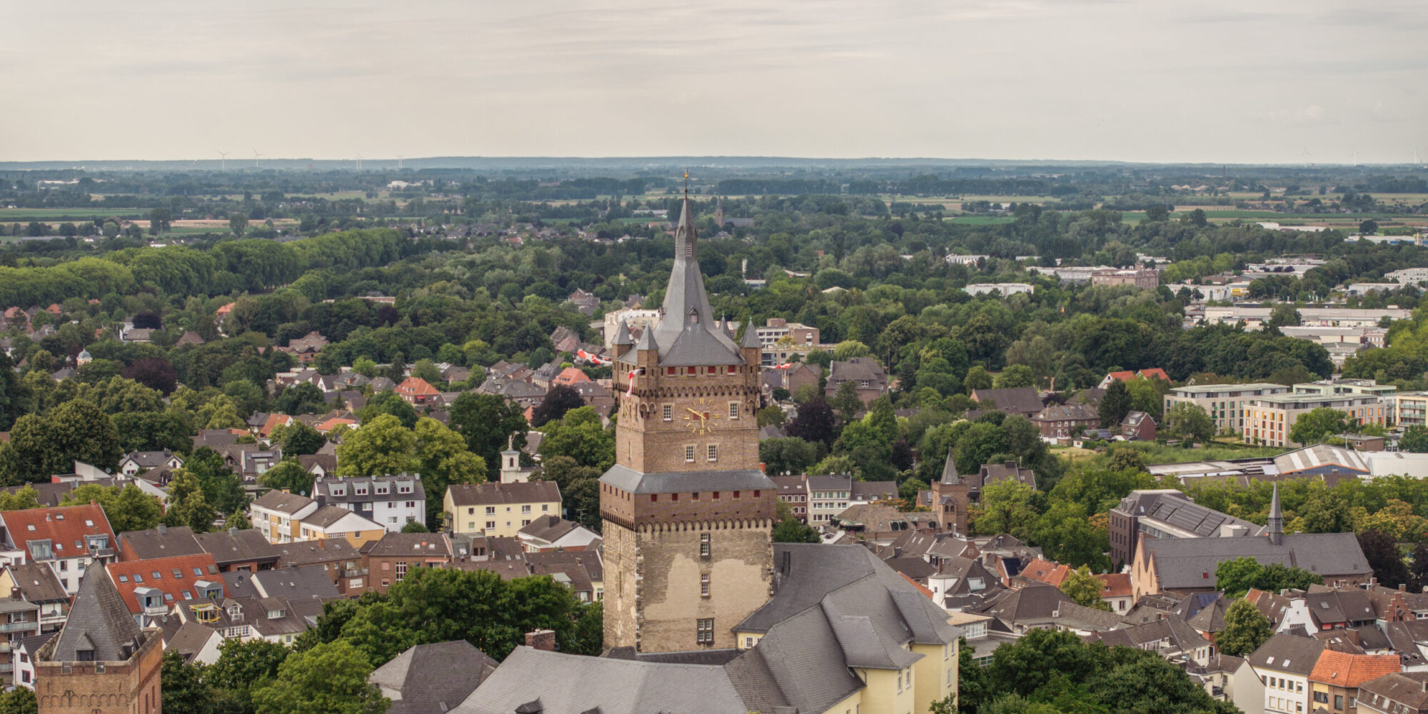 Blick aus der Luft auf die Schwanenburg inmitten der Stadt Kleve mit Bäumen im Vordergrund