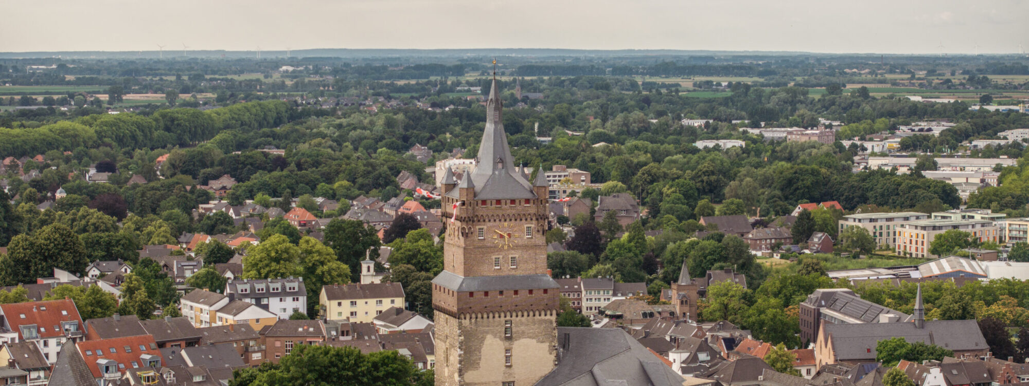 Blick aus der Luft auf die Schwanenburg inmitten der Stadt Kleve mit Bäumen im Vordergrund