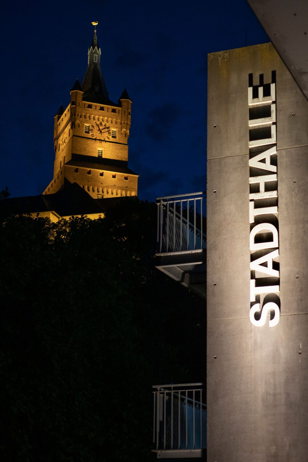 Stein mit Schriftzug "Stadthalle" im Hintergrund die Schwanenburg