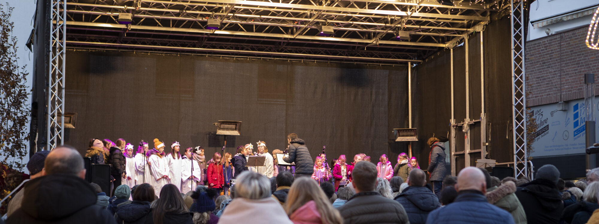 Viele Menschen stehen vor einer Bühne auf dem Klever Weihnachtsmarkt