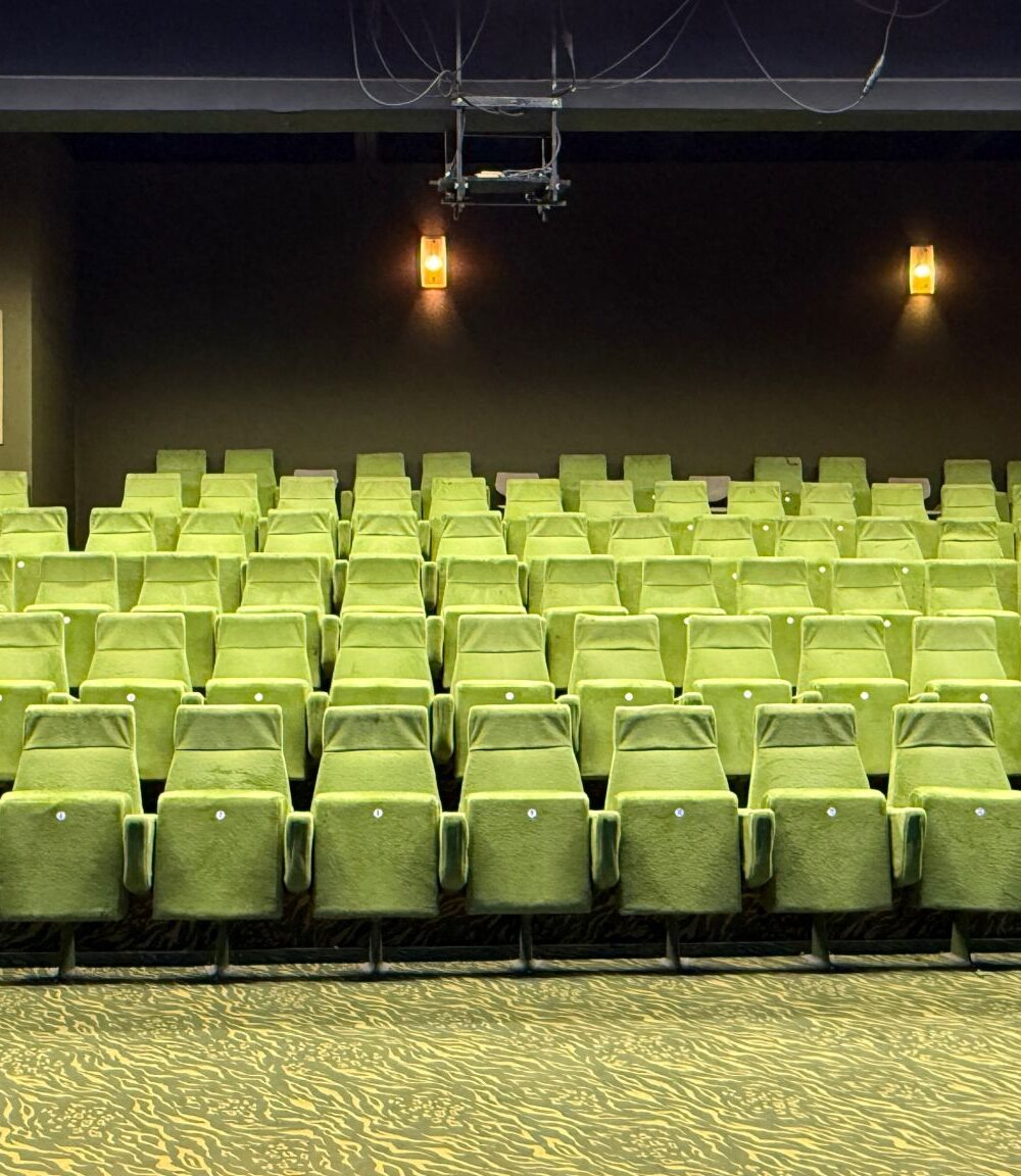 Theater, Raum mit grünen Stoffsitzen