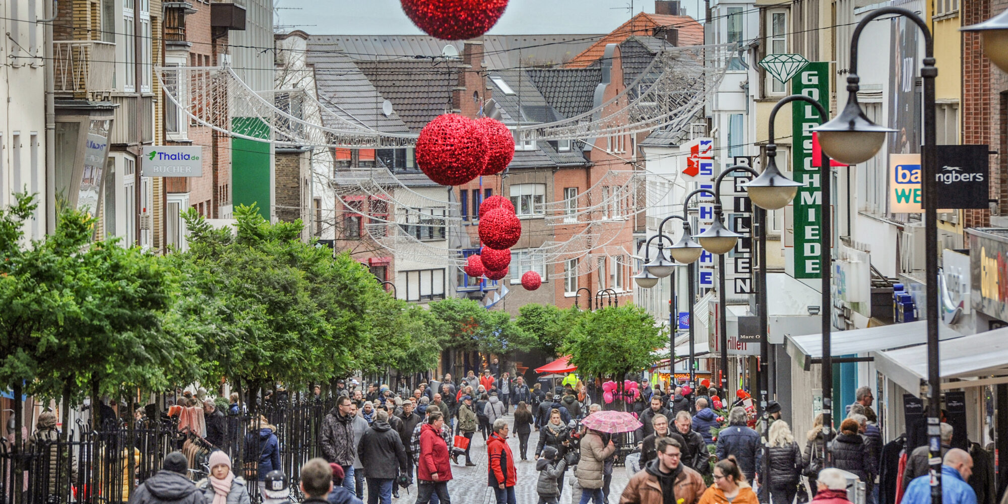 Menschen befinden sich in einer Innenstadt mit Weihnachtsbeleuchtung